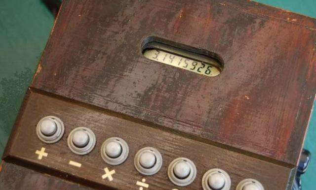 Vemos aqui una vieja calculadora en madera café  con botones y cada uno indica una delas cuatro operaciones 
